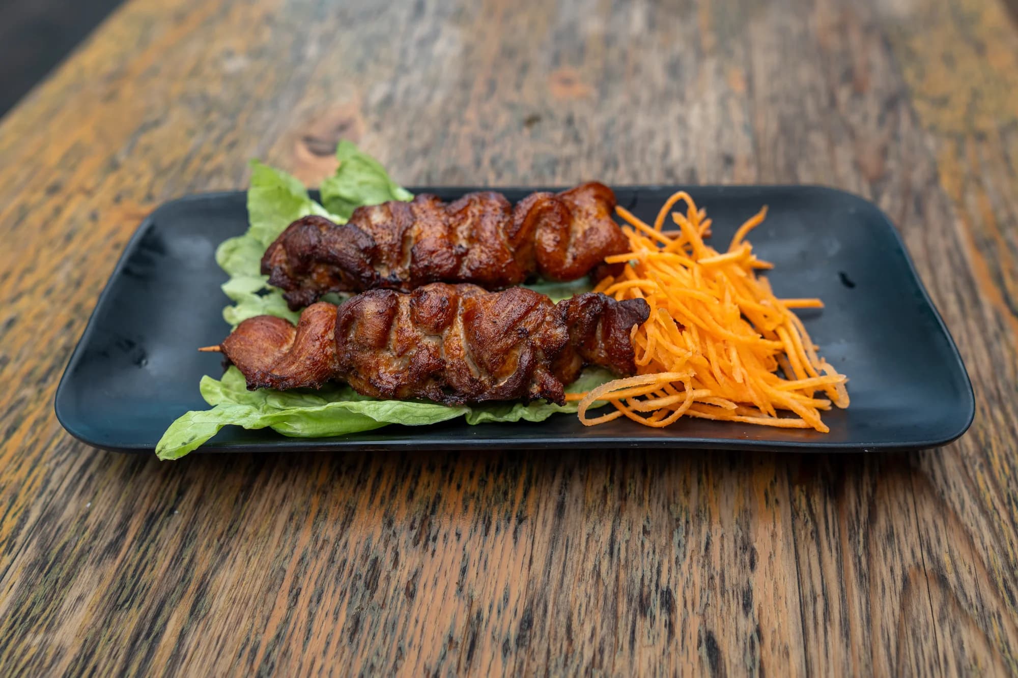 Grilled skewers on a black serving plate at Viet Nom Nom, New Plymouth