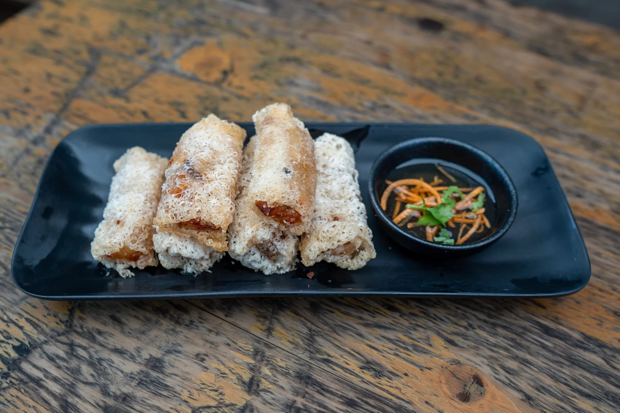 Crisp net spring rolls on a black plate at Viet Nom Nom, New Plymouth