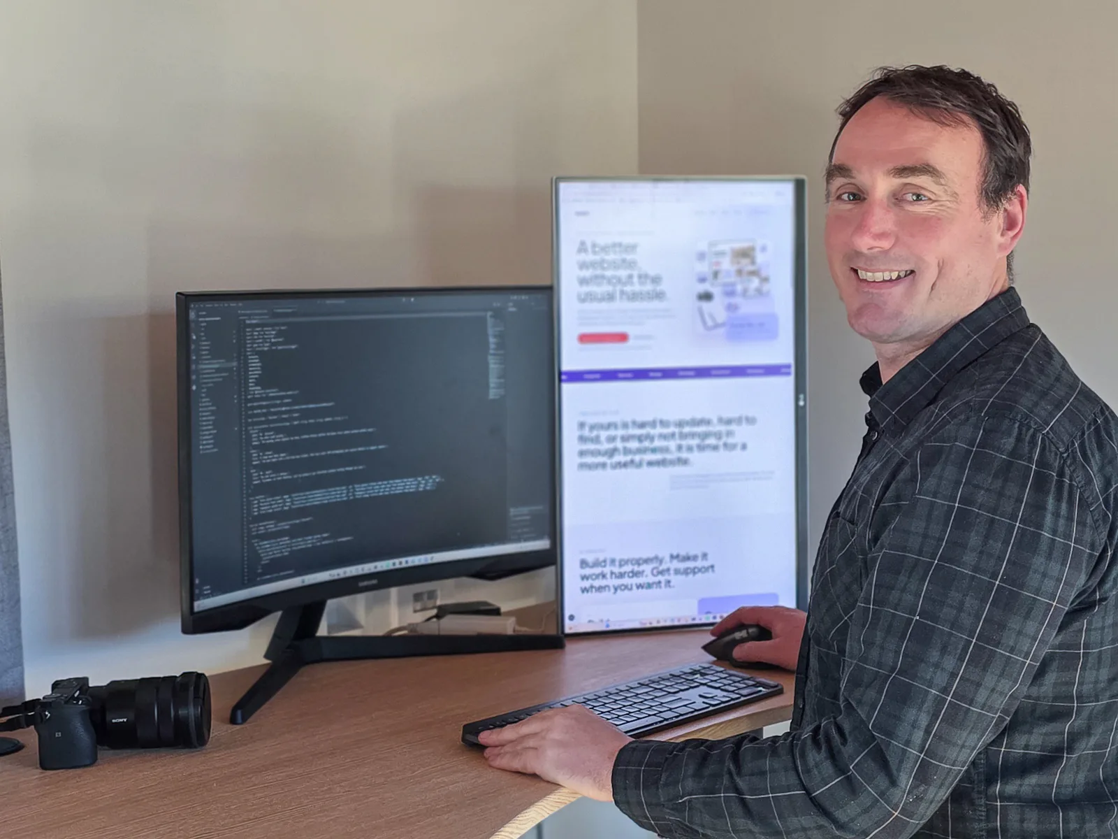 Tamron Galbraith working at his desk with website development and photography equipment